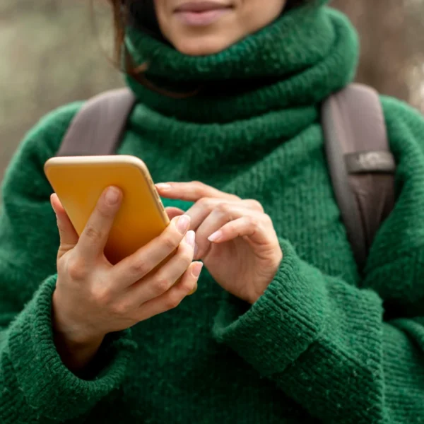 A hiker looks at her phone in the forest.