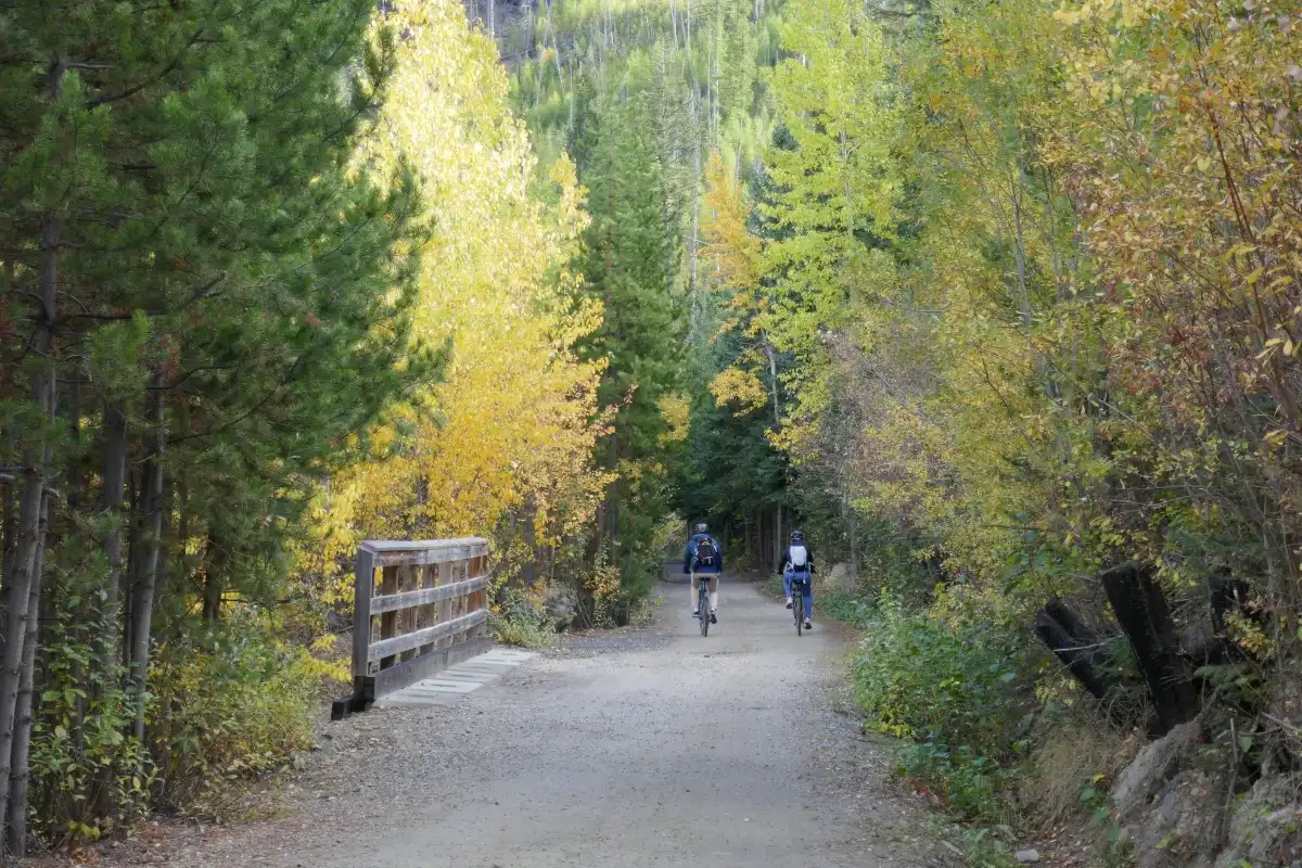 Two people enjoy biking on the Kettle Valley Rail Trail at Myra Canyon.