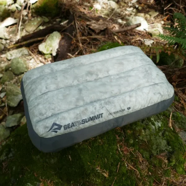 An Aeros Down pillow sits on a rock.