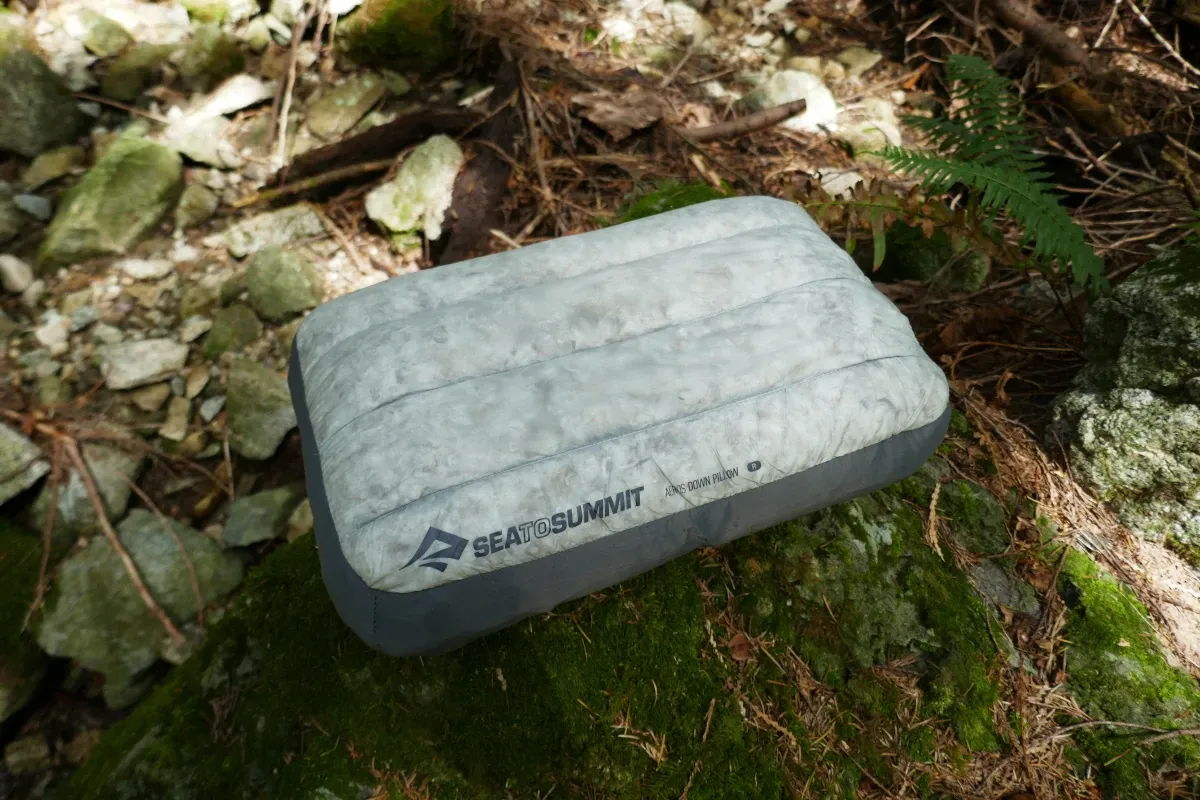 An Aeros Down pillow sits on a rock.