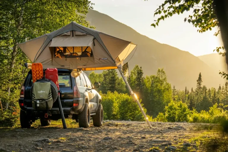 A vehicle with a rooftop tent camps on a industry road.