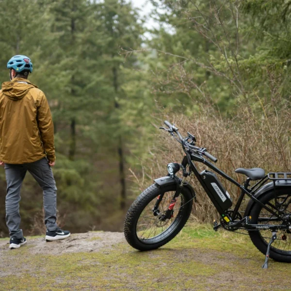 A man stands next to an e-bike in the forest.